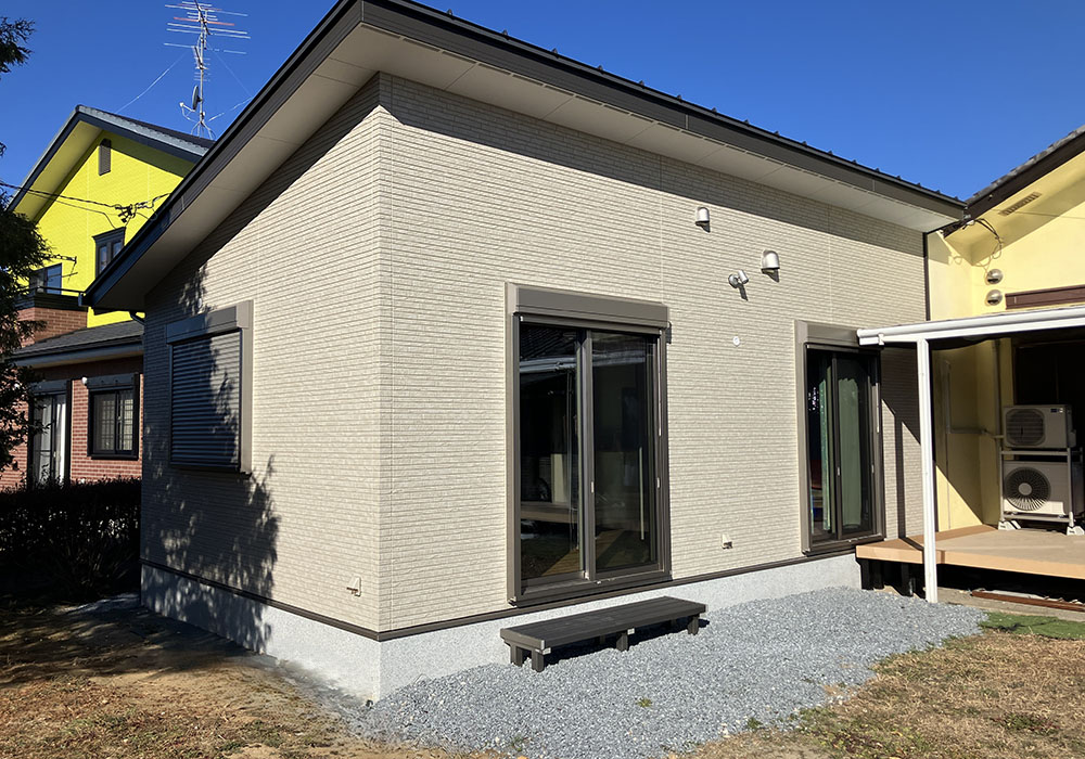 家族がウッドデッキでくつろぐ家の外観