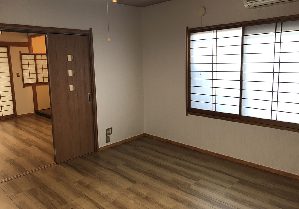 吹き抜けリビングで家族が過ごす明るい木の家の内観